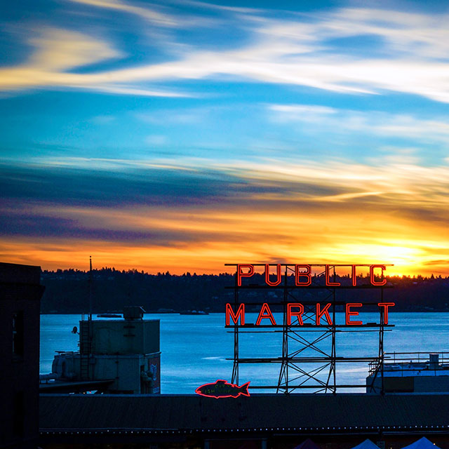Seattle Public Market sign against a sunset backdrop